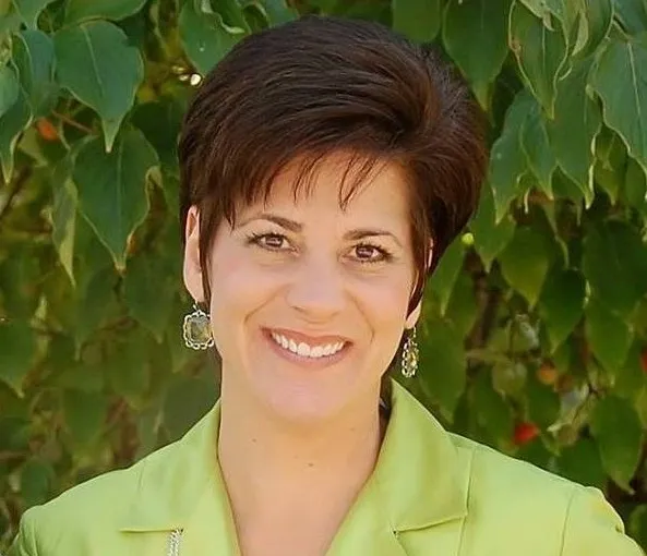 A woman with short hair wearing a green shirt.